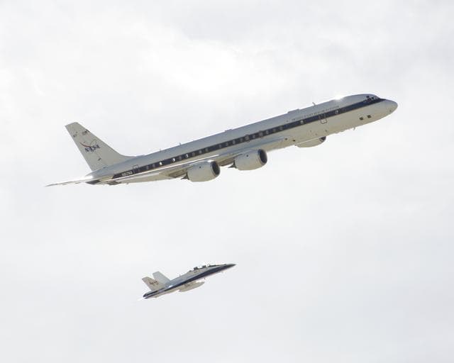 NASA image: NASA's DC-8 airborne science laboratory is shadowed by a NASA F/A-18 chase plane during a flyover of the Dryden Aircraft Operations Facility in Palmdale, Calif.