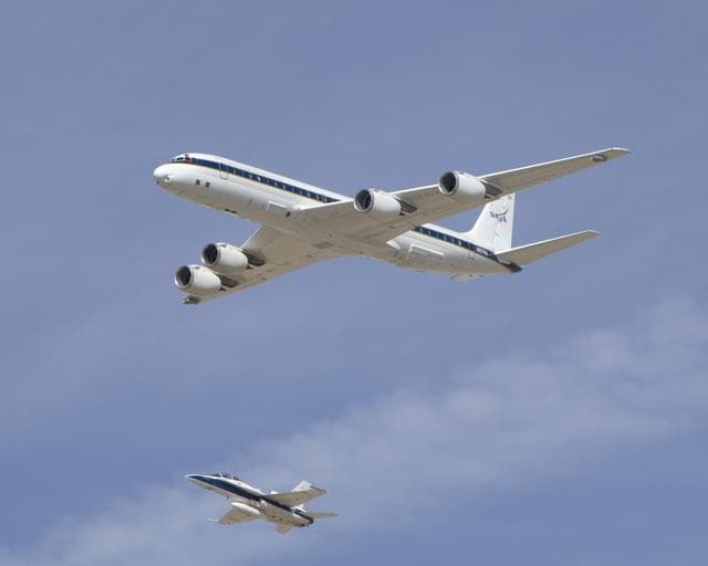 NASA image: NASA's DC-8 airborne science laboratory is shadowed by a NASA F/A-18 chase plane during a flyover of the Dryden Aircraft Operations Facility in Palmdale, Calif.
