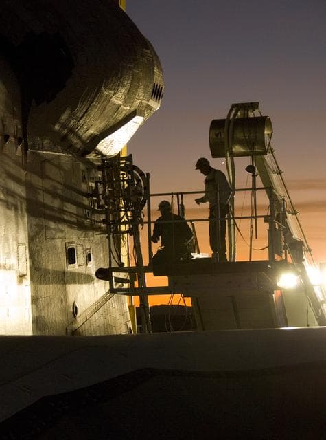 NASA image: As dusk settles over Edwards Air Force Base, NASA technicians hook up various ground-support systems before shuttle Endeavour is towed off the landing runway