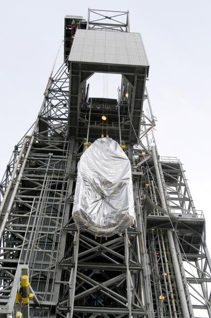 NASA image: KENNEDY SPACE CENTER, FLA. -  At Launch Complex 17-A, Cape Canaveral Air Force Station, the first half of the fairing for the Mars Exploration Rover 2 (MER-2/MER-A) is lifted up the launch tower.  The fairing will be installed around the payload for protection during launch.  The MER Mission consists of two identical rovers designed to cover roughly 110 yards each Martian day over various terrain. Each rover will carry five scientific instruments that will allow it to search for evidence of liquid water that may have been present in the planet's past.  Identical to each other, the rovers will land at different regions of Mars.  Launch date for MER-A  is scheduled for June 5.