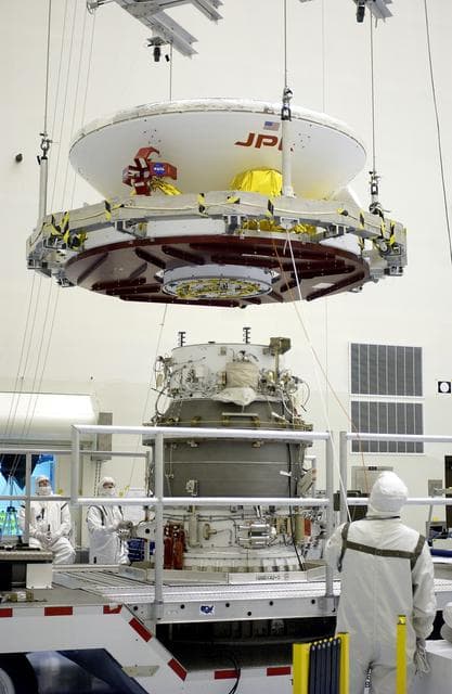 NASA image: KENNEDY SPACE CENTER, FLA. -  In the Payload Hazardous Servicing Facility, workers prepare to mate the Mars Exploration Rover-2 (MER-2) to the third stage of a Delta II rocket for launch on June 5.  NASA’s twin Mars Exploration Rovers are designed to study the history of water on Mars. These robotic geologists are equipped with a robotic arm, a drilling tool, three spectrometers, and four pairs of cameras that allow them to have a human-like, 3D view of the terrain. Each rover could travel as far as 100 meters in one day to act as Mars scientists' eyes and hands, exploring an environment where humans can’t yet go.  MER-1 (MER-B) will launch June 25.