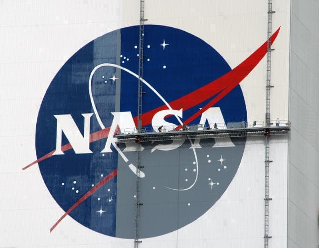 NASA image: Workers painting the Flag and Meatball on the VAB