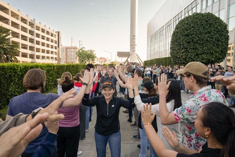 NASA image: NASA astronaut Anne McClain smiles and high fives SpaceX employees